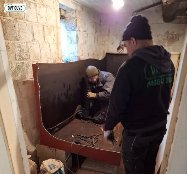 2 ouvriers de DVF cuve sont en train de découper une citerne mazout métallique dans une cave